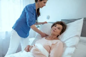 Home caregiver adjusting a pillow for an older woman