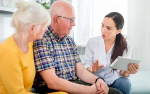 Nurse explaining care options to an older couple at home