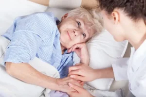 Palliative care nurse comforting a patient with a serious illness