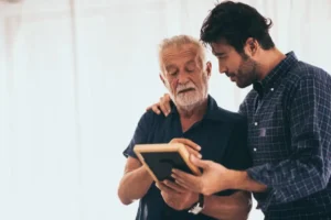 Cheerful older man sitting with a family member
