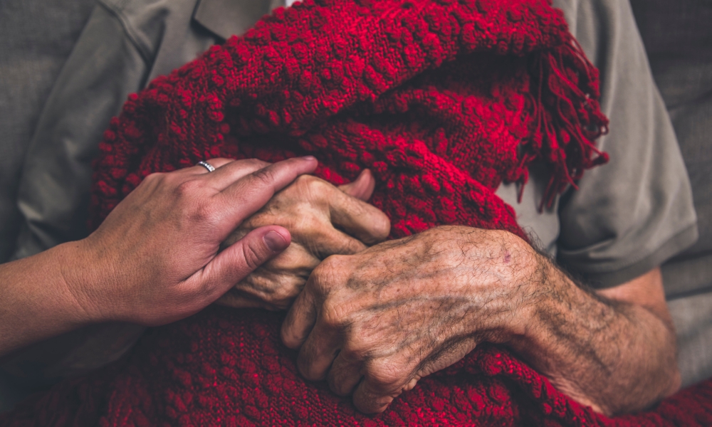 Hospice nurse supporting a patient with advanced cancer at home