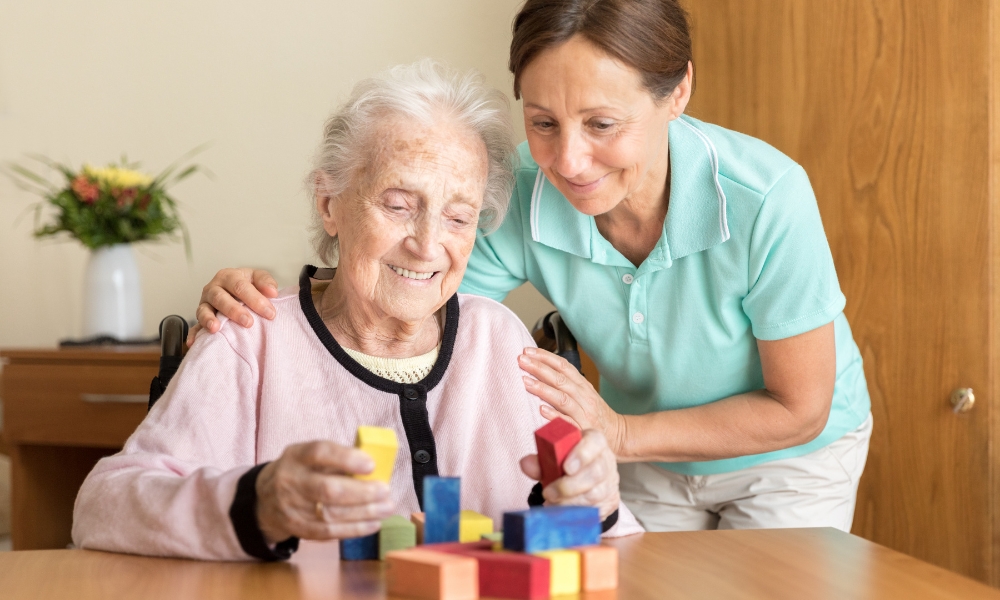 Caregiver supporting elderly patient with advanced dementia at home