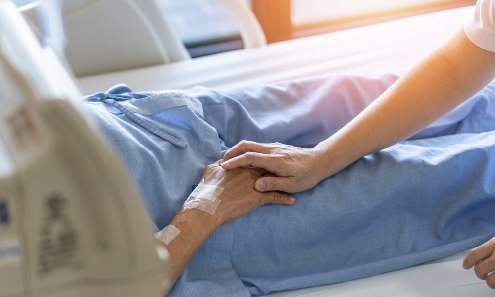 Hospice nurse providing bedside care to elderly patient at home